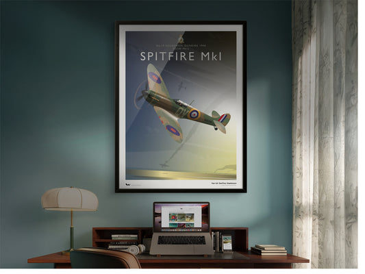 Framed poster of a Spitfire MkI airplane on a wall above a desk with a laptop. The laptop and phone are both showing the Wisdom Art Prints website.